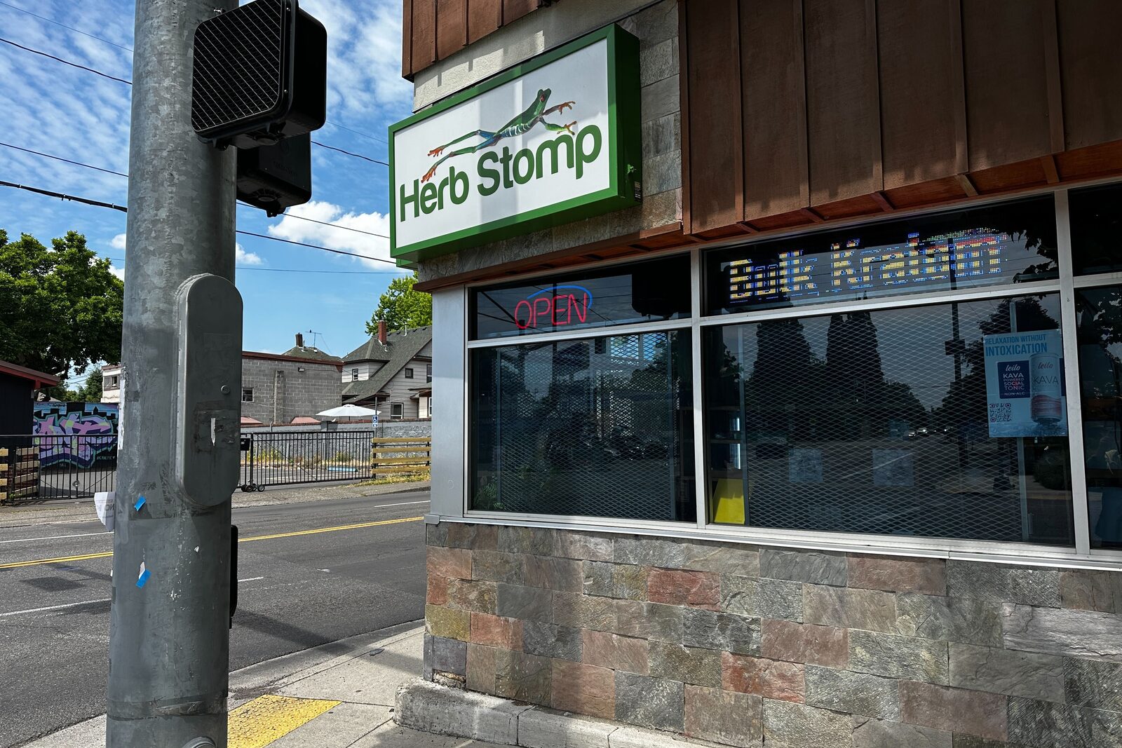 The Herb Stomp storefront on NE Sandy Blvd in Portland, Oregon, green sign lit and OPEN neon in the window