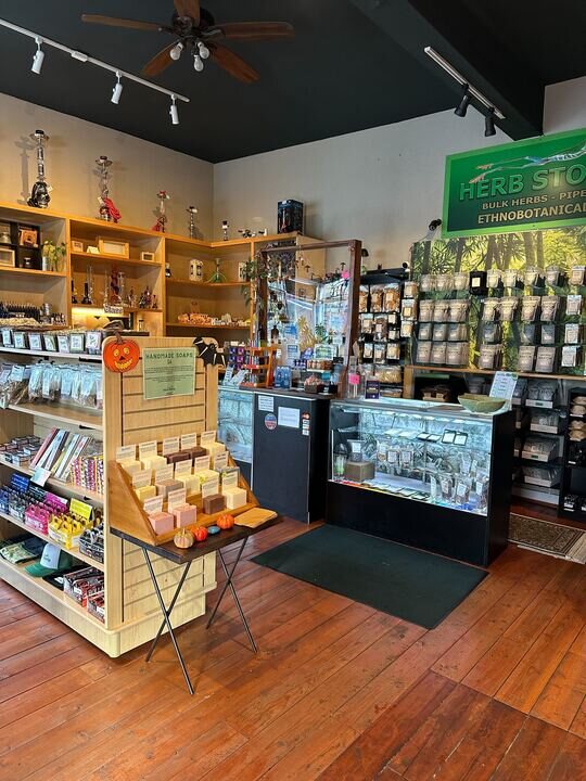 Inside Herb Stomp — the green Herb Stomp sign above the wall of bagged herbs and the soap display